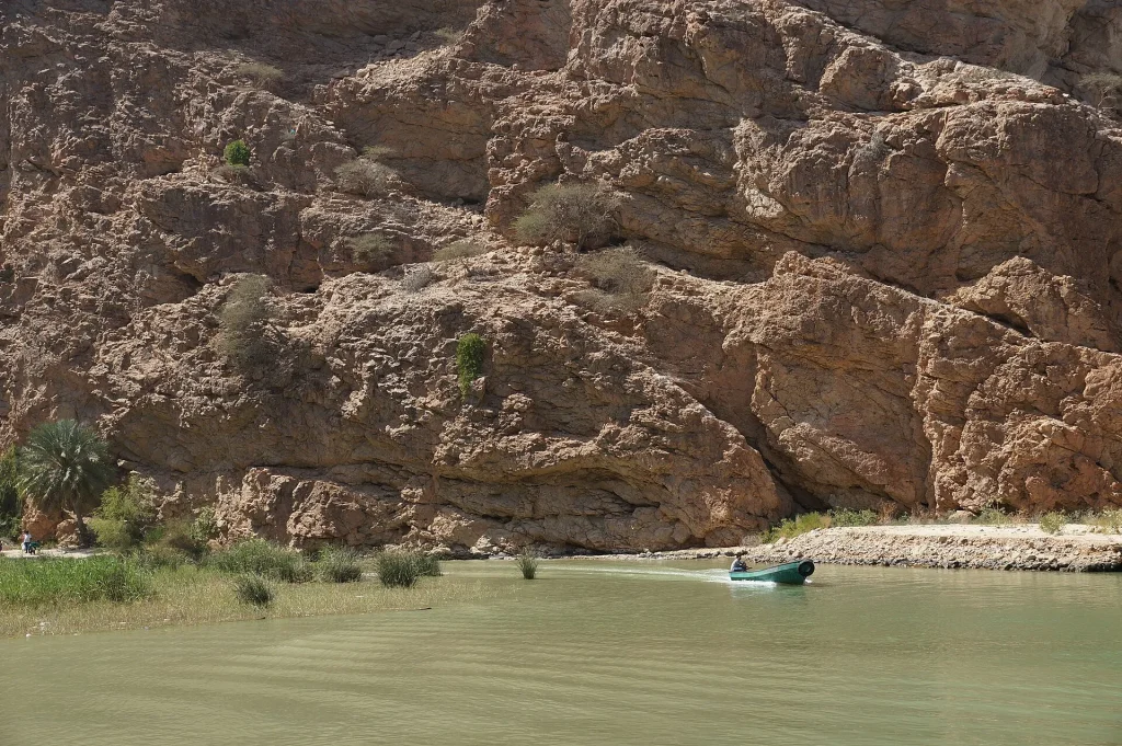 Small boat crossing at the entrance of Wadi Shab